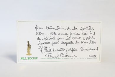 BOCUSE : Billet autographe de Paul Bocuse adressé à son amie Jani Brun sur un carton publicitaire de son restaurant à Collonges-au-Mont-d'Or le 3 Mars 1987 - Libro autografato, Prima edizione - Edition-Originale.com